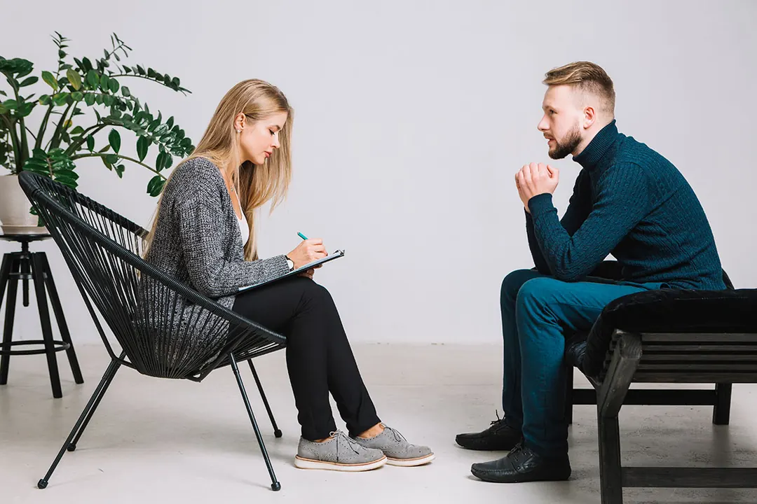 A kindfulness therapist in a calm, friendly counselling session with a client